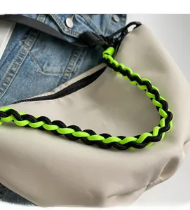 Detailed close-up of beige nylon crossbody bag with dual-tone braided rope shoulder strap
