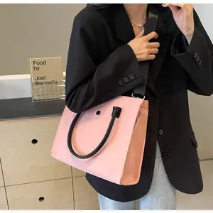 Pink PU leather tote bag with black handles and metal ring detail shown on model