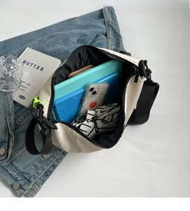 Detailed interior view of a white nylon crossbody bag showing its large storage capacity