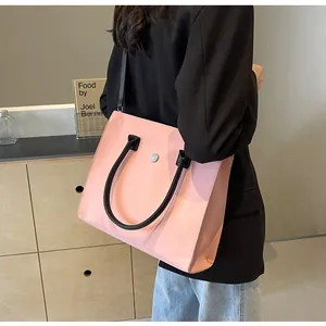 Fashionable pink tote bag with black handles and silver buckle shown in a lifestyle scene