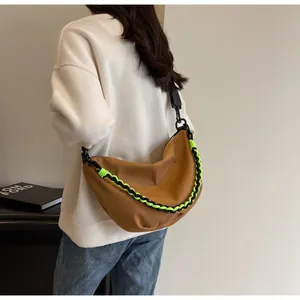 Brown nylon crescent bag detail showing woven neon accent and black adjustable shoulder strap