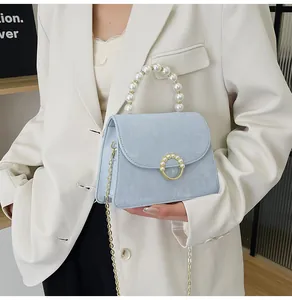 Detailed view of light blue crossbody bag with pearl handle and cloud texture finish