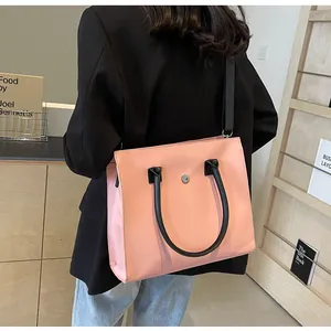 Pink tote bag with black handles shown on a model in a minimalist lifestyle setting