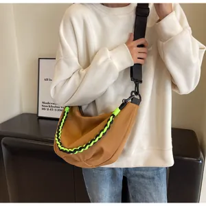 Brown nylon crescent bag detail with neon green braided rope and adjustable strap