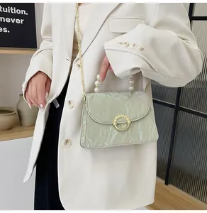Detail of mint green marble texture bag with pearl handle and golden chain strap