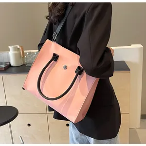 Detailed view of pink tote bag featuring black wide shoulder strap and silver metal buckle