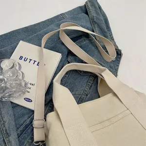 Macro view of a cream canvas tote bag with thick texture on denim background