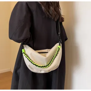 Detail of off-white nylon half-moon bag with neon green woven chain and zipper