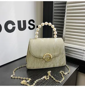 Detail of light green marble texture bag with pearl handle and golden chain strap