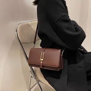 Chic dark brown faux leather crossbody flap bag with gold U-shaped metal buckle for women
