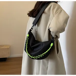Detail of black nylon crescent bag with neon green woven cord and adjustable wide strap