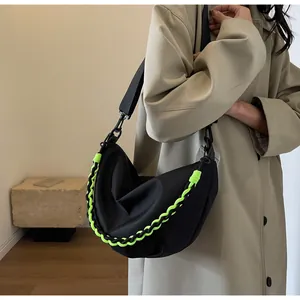 Detail shot of black nylon crescent moon bag with bright neon green braided chain accents
