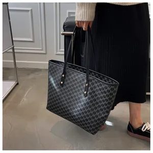 Dettaglio della grande borsa tote nera con stampa monogramma classica e rivetti dorati