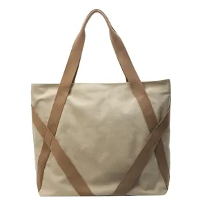 Minimalist beige canvas tote bag with brown X-shaped reinforced straps for daily use