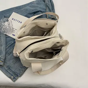 Internal view of beige canvas tote bag showing zipper compartments and large capacity storage
