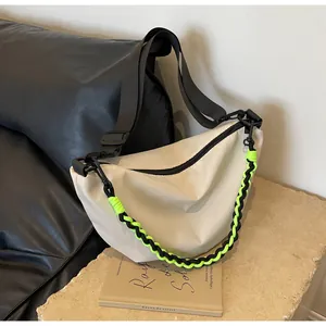 Detail of off-white nylon crescent bag featuring a vibrant neon green braided chain strap