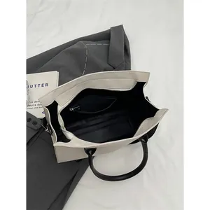 Minimalist black and white tote bag with spacious interior and zipper closure from above