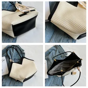 Detail view of stylish tote bag showing pleated fabric texture and internal pockets