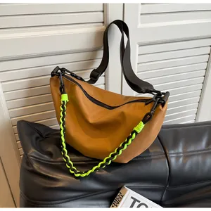 Detail of caramel nylon crescent bag with adjustable strap and neon rope chain decoration
