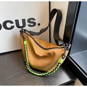 Detail of khaki nylon crossbody bag with neon green woven chain and adjustable strap