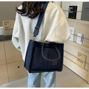 Dettaglio della borsa tote in tela blu navy con tracolla in un contesto lifestyle