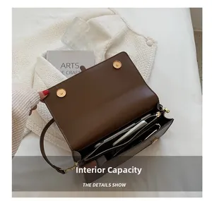Detail of dark brown leather crossbody bag showing multiple inner compartments and zipper