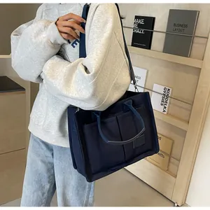Dettaglio della borsa tote in tela blu navy con tasche e tracolla regolabile morbida