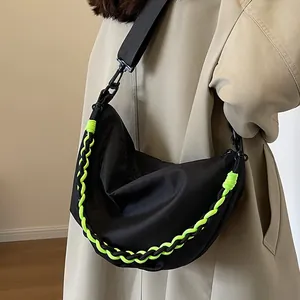 Large black nylon crescent hobo bag with vibrant neon green woven chain detail