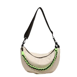 Crescent nylon crossbody bag in off-white with vibrant neon green woven chain strap