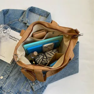 Large khaki canvas tote bag with multiple compartments showing spacious inner storage