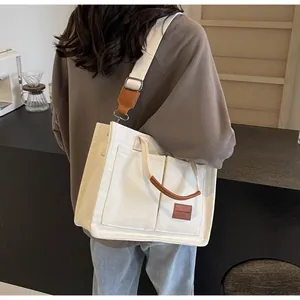 Vista posteriore dettagliata di una borsa tote in tela bianca con dettagli in cuoio
