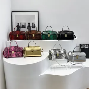 Kollektion von Handtaschen mit Schlangenmuster in verschiedenen Farben und Goldverschluss
