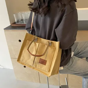 Borsa tote in tela giallo senape con tasche anteriori e dettagli in pelle per uso casual