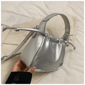 Detailed view of silver metallic pleated bucket bag with adjustable shoulder strap