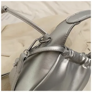 Macro detail of silver cloud bag showing metallic pleated texture and spring metal buckle