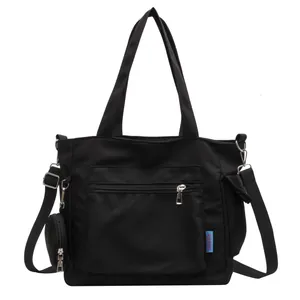 Large black canvas tote bag with front pocket and small coin purse attachment