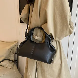 Close-up of matte black lychee pattern leather handbag with gold-tone hardware