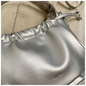 Detailed macro view of the silver pleated cloud bag featuring the chirab logo engraving