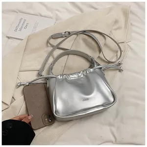 Silver metallic drawstring bag detail showing compact size with a smartphone reference