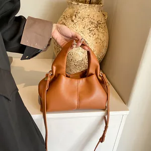 Detail of caramel brown leather handbag with lychee texture and pleated design