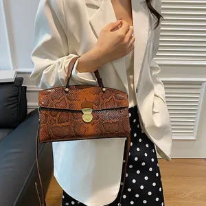 Detail der Vintage-Handtasche mit Schlangenmuster, goldenem Schloss und Schulterriemen