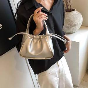 Close-up of metallic silver drawstring handbag showing PU leather texture and pleats