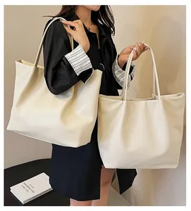 Minimalist cream leather tote bag set showing both large and small sizes on a black table
