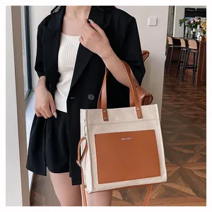 Close-up of MYCARE canvas tote bag with brown leather pocket and adjustable shoulder strap