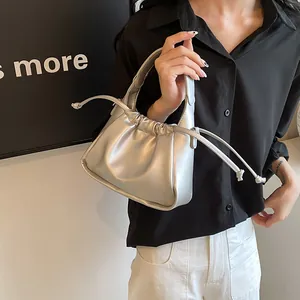 Chic silver pleated cloud bag featuring drawstring detail and sleek round handle grip