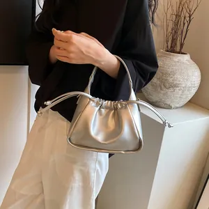 Detail of silver drawstring cloud bag showing smooth metallic PU finish and top handle