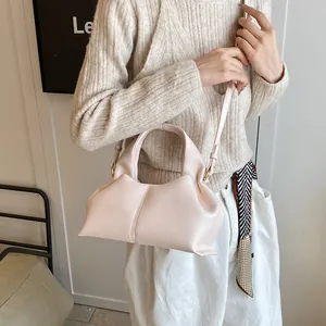 Detail of lychee pattern leather handbag in milky tea color with detachable strap
