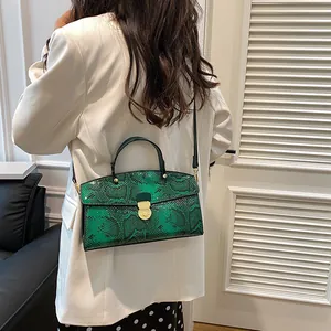 Detailansicht der grünen Schlangenleder-Handtasche mit goldener Schließe und Retrostil