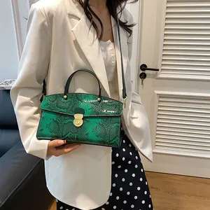 Grüne Damenhandtasche mit Schlangenmuster, getragen zu einem schicken weißen Blazer
