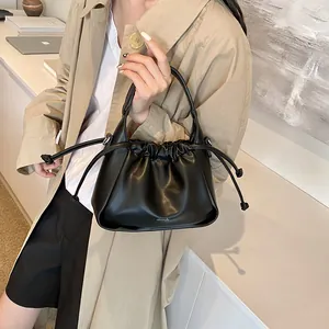 Detailed view of the black cloud bag with drawstring closure and curved handle